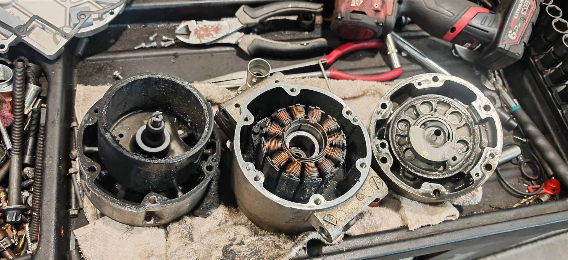 Electric vehicle motor stator repair showing disassembled motor components during hybrid vehicle servicing