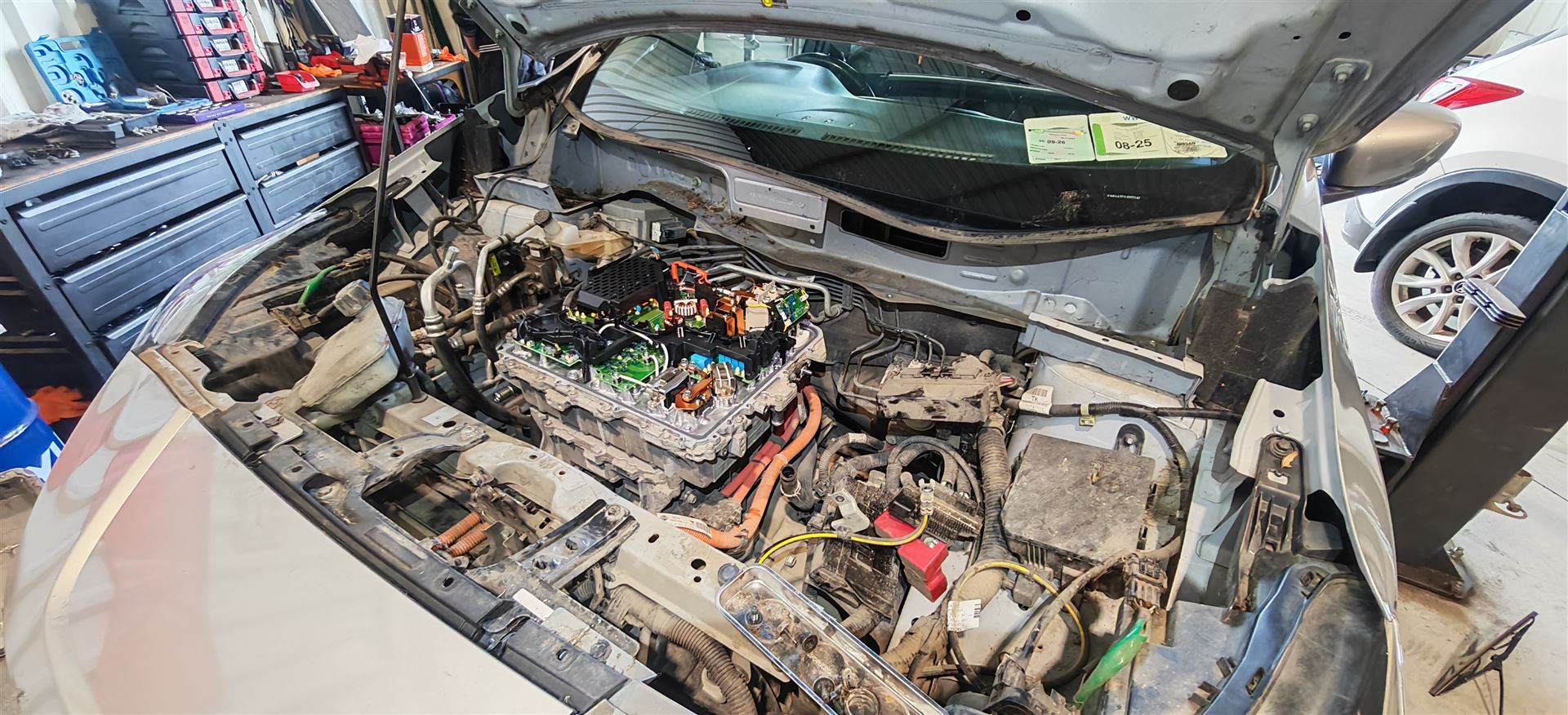 Electric vehicle high voltage system repair with exposed battery components during professional EV servicing