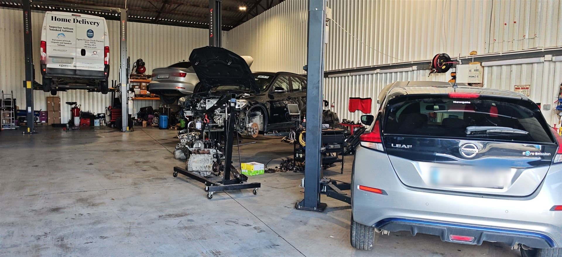 Nissan Leaf electric vehicle undergoing inspection and repair inside a professional EV workshop
